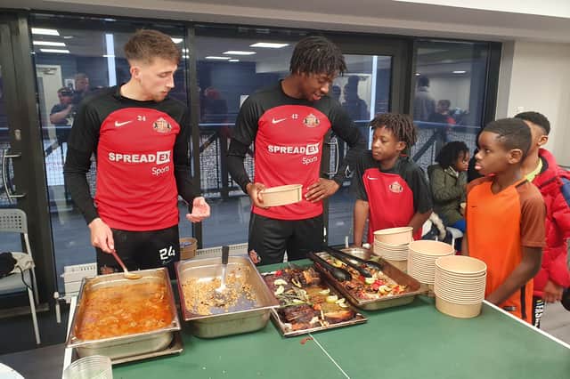 Dan Neil and Aji Alese enjoying Afro-Caribbean food with youngsters at a previous event at the Academy of Light.